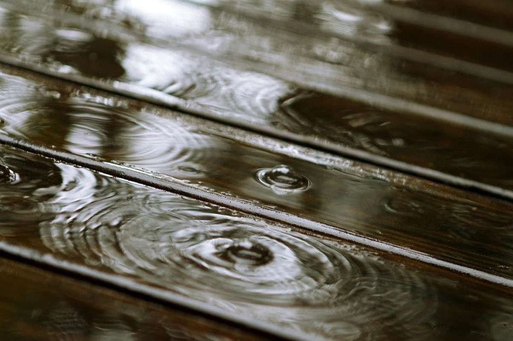 wet wooden floor with ripples from water droplets